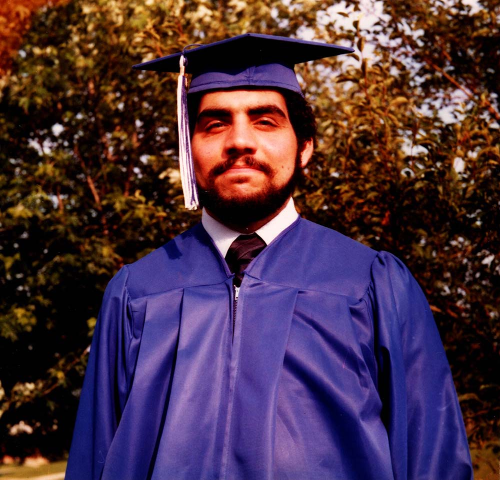 A picture of Ed Frank in a blue high school graduation cap and gown.