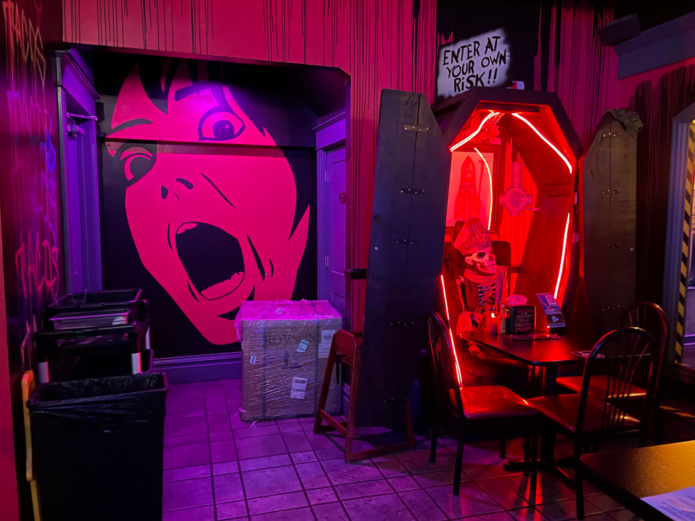 Horror themed decor at Terror Tacos including a scream painting and a coffin